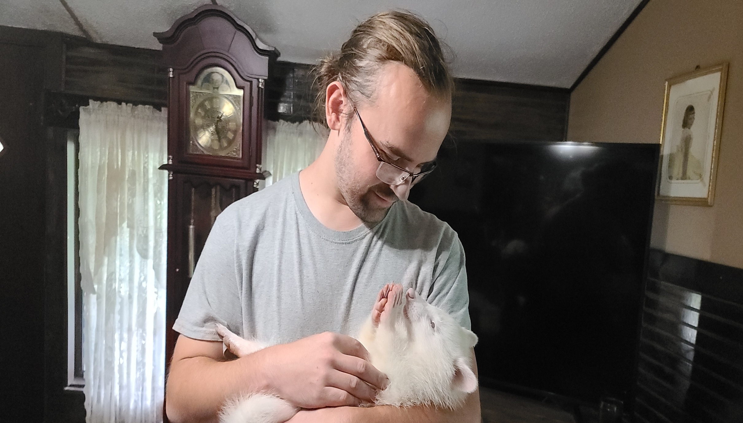 a photo of a man holding an albino pet raccoon at exotic pet wonderland